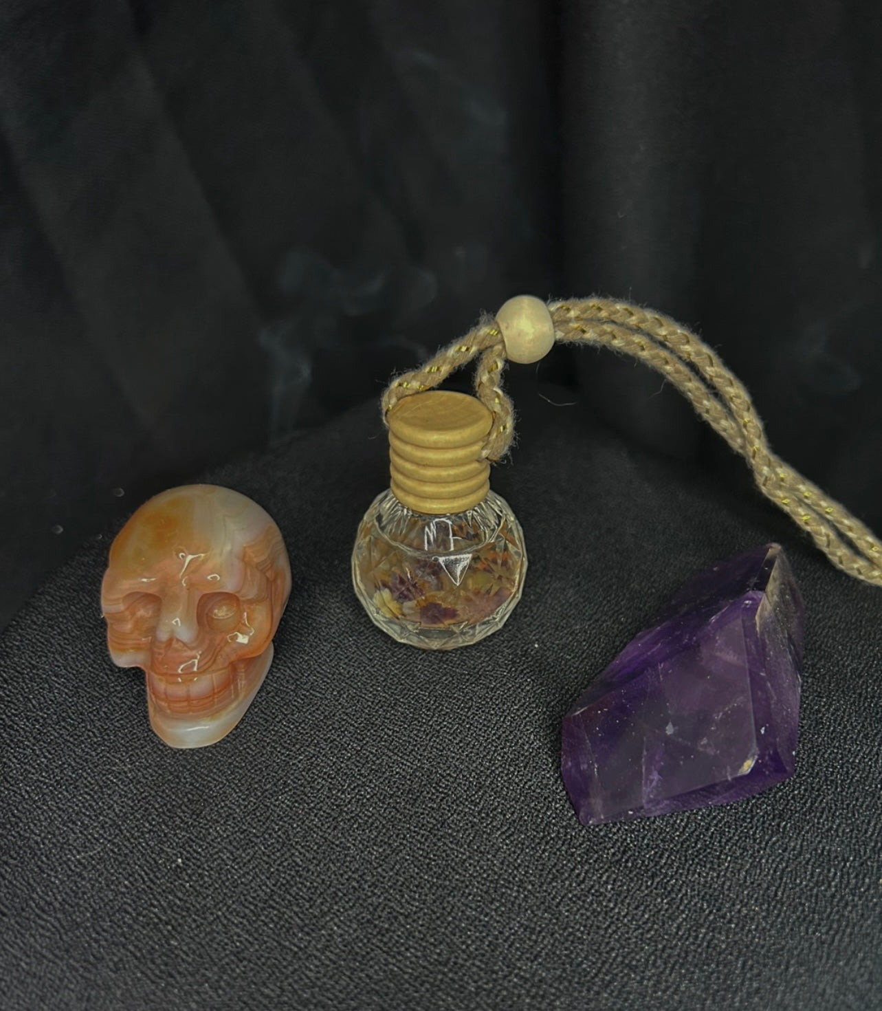 mobile fragrance diffuser pictured with stones on a black service